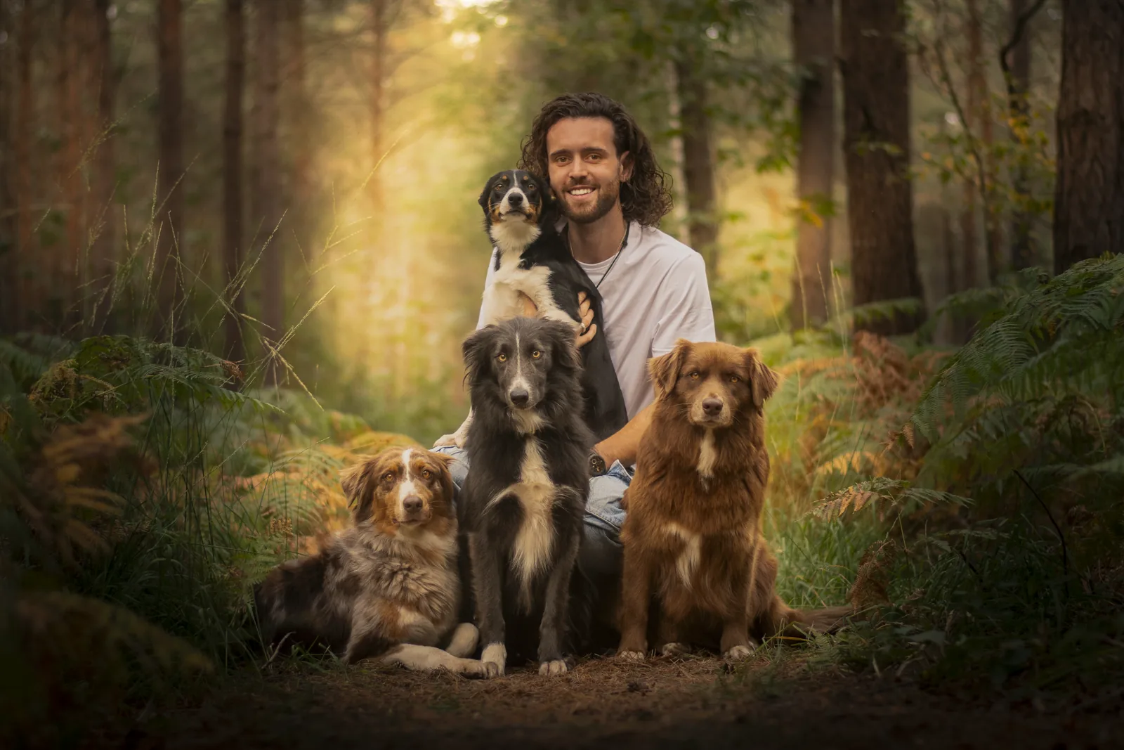 Florian, éducateur canin Caniconcept, entouré de ses quatre chiens en forêt près de Rouen