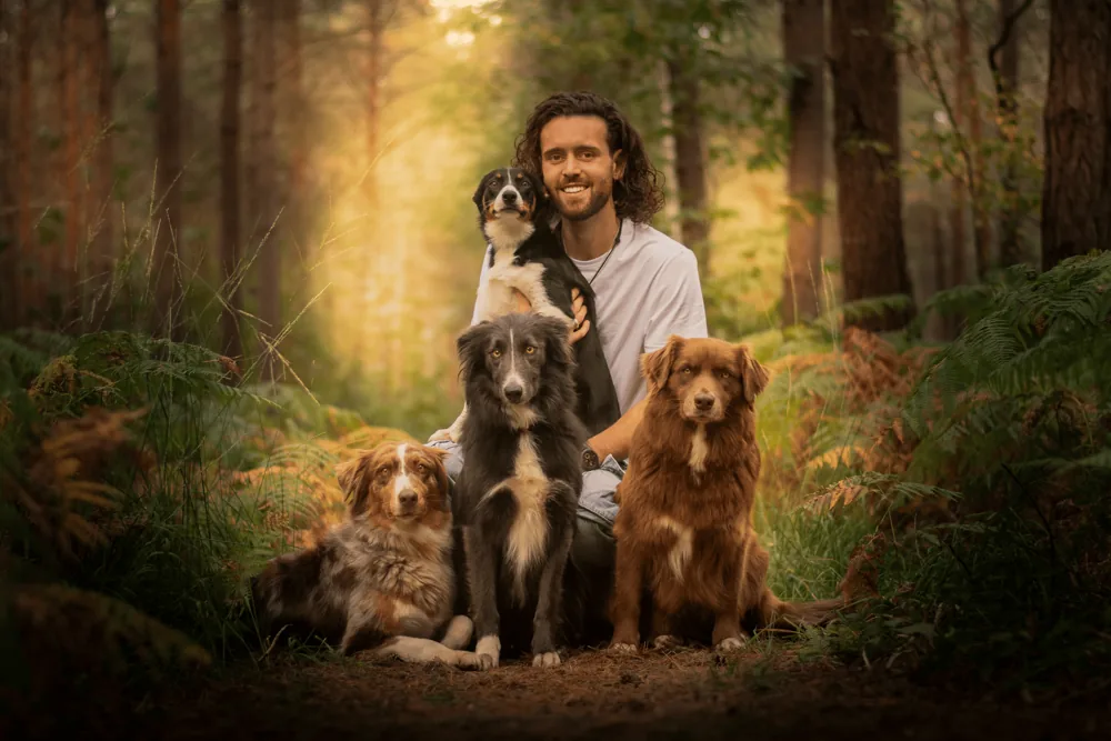 Florian Caniconcept entouré de ses chiens dans une forêt en automne