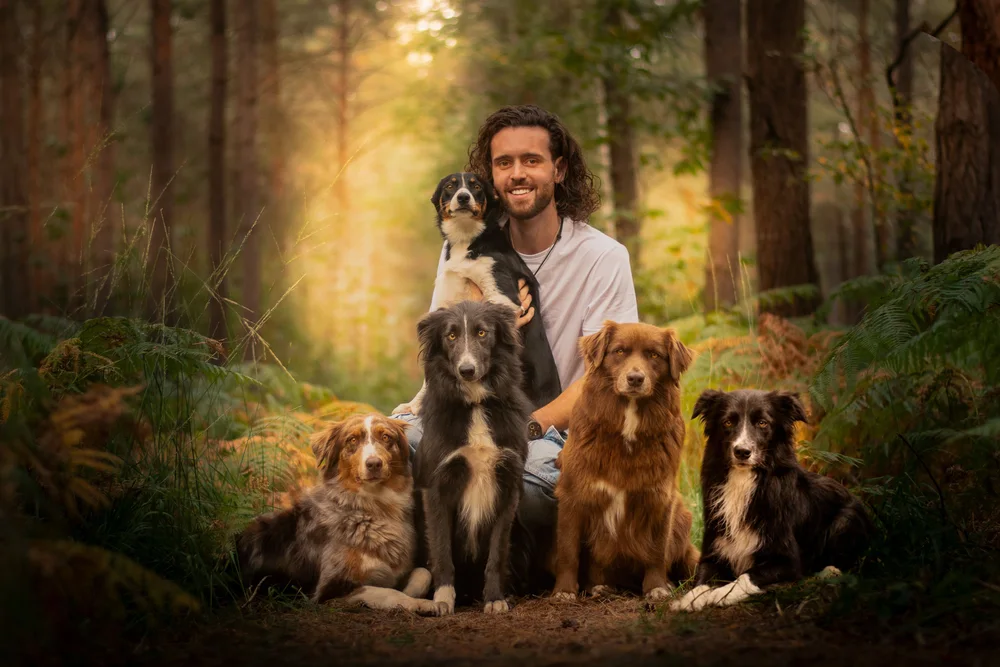 Florian Caniconcept entouré de ses chiens dans une forêt en automne
