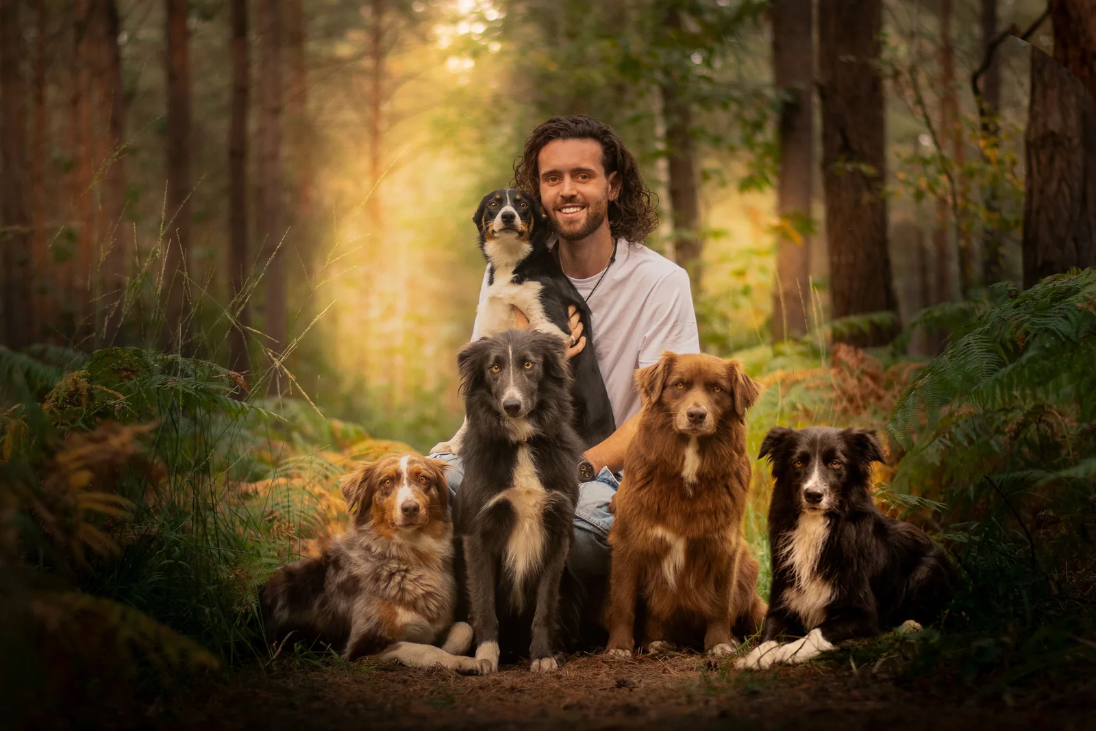 Florian, éducateur canin Caniconcept, entouré de ses quatre chiens en forêt près de Rouen
